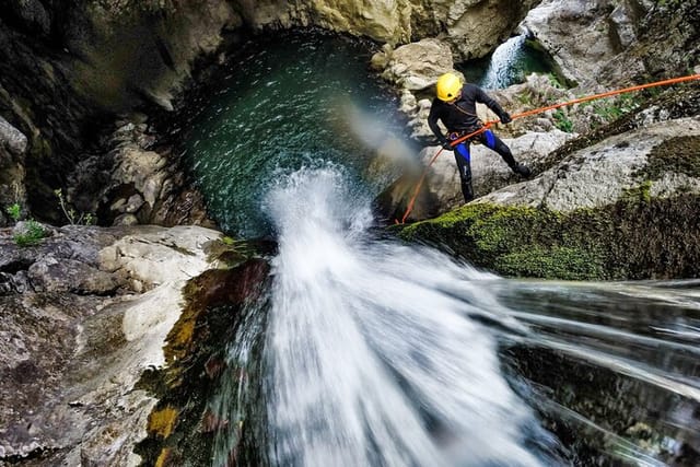 Rappelling down a waterfall into a spectacular canyon grotto
